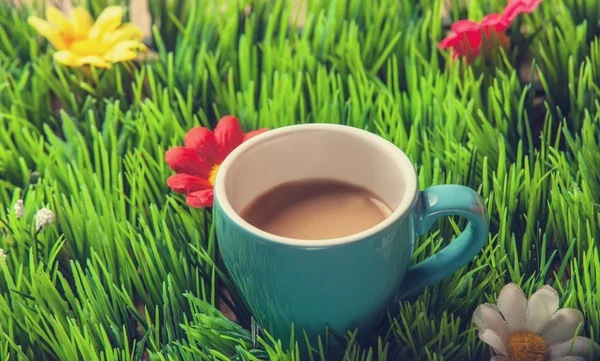 Cup of coffee on green grass. — Stock Photo, Image