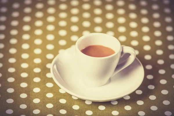 Cup of a coffe on polka dot cover. — Stock Photo, Image