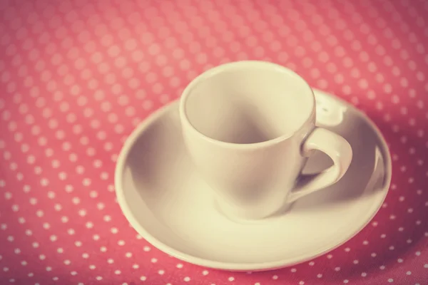Cup of a coffee on polka dot cover. — Stock Photo, Image