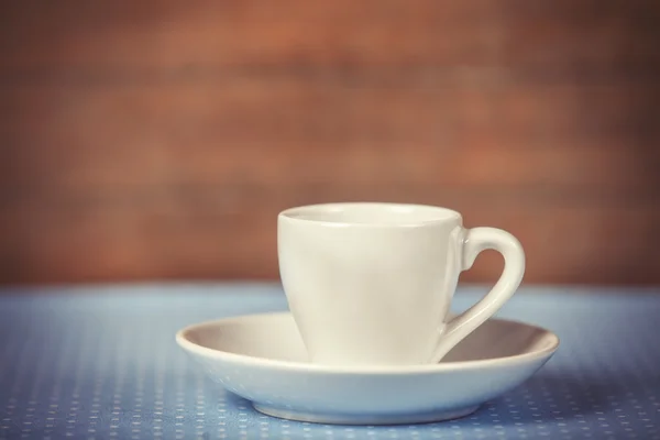 Beker van een kopje koffie op polka dot cover. — Stockfoto