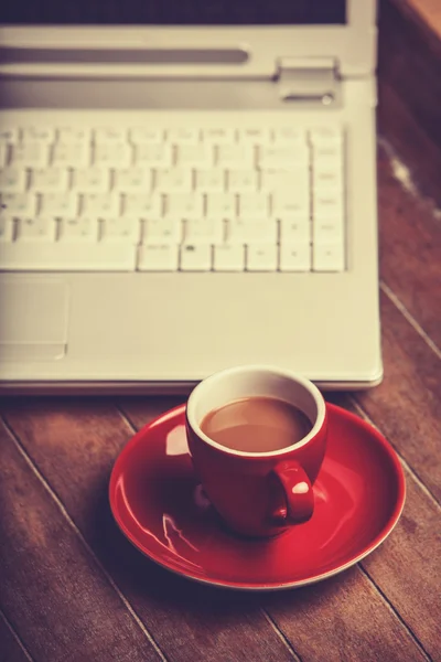 Taza de café y portátil en mesa de madera. — Foto de Stock