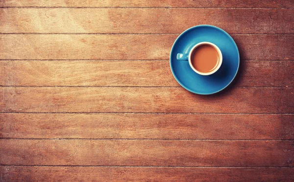 Filiżanka kawy na drewnianym stole. — Zdjęcie stockowe
