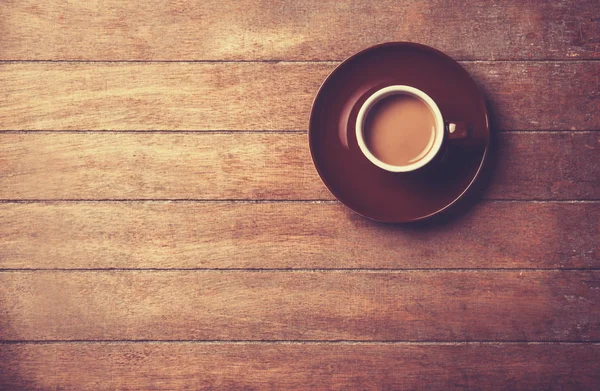 Una taza de café sobre una mesa de madera. — Foto de Stock