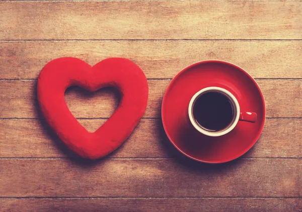 Cup of coffee and shape heart on a wooden table. — Stock Photo, Image