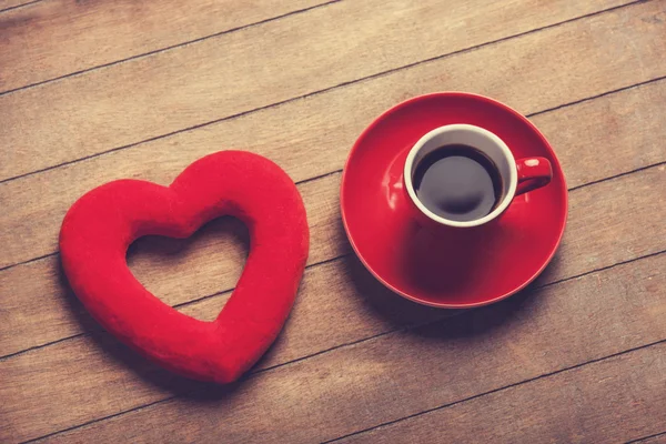 Φλιτζάνι καφέ και το σχήμα καρδιάς σε έναν ξύλινο πίνακα. — Φωτογραφία Αρχείου