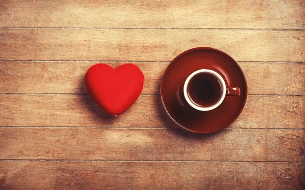 Cup of coffee and shape heart on a wooden table. — Stock Photo, Image