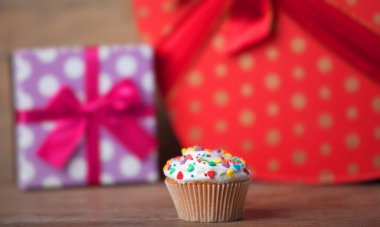 ahşap bir masa üzerinde hediyeler ile kremalı pasta.