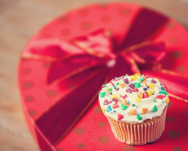 Cream cake with gifts on a wooden table. — Stock Photo, Image