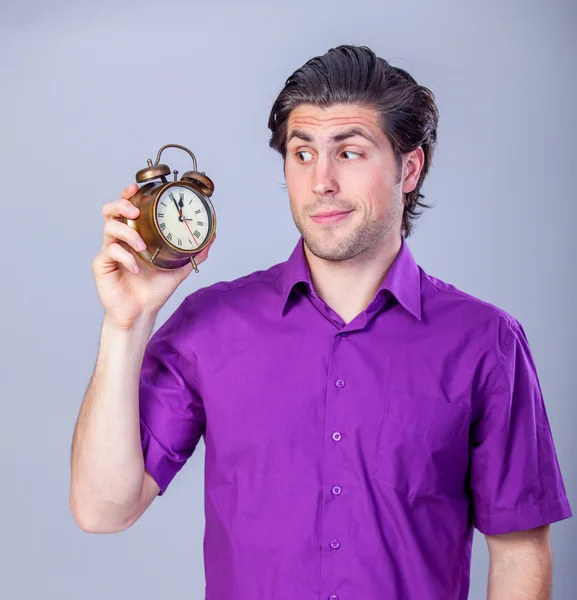 Handsome man with alarm clock — Stockfoto