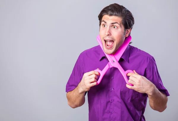 Man met een enorme schaar op grijze achtergrond. — Stockfoto