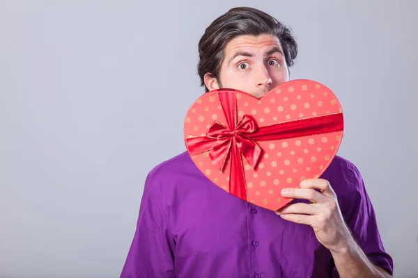 Hombre guapo con regalo sobre fondo gris . —  Fotos de Stock