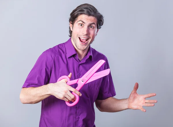 Man with huge scissors on gray background. — Stock Photo, Image