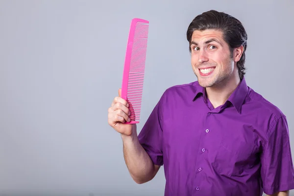 Man with huge comb on gray background. — Stock Photo, Image