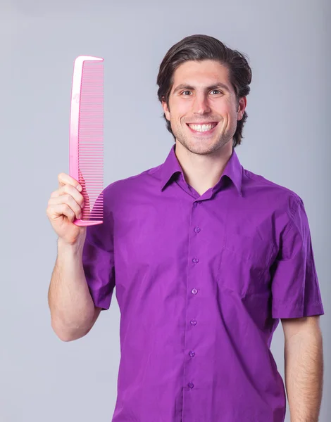 Man with huge comb on gray background. — Stock Photo, Image