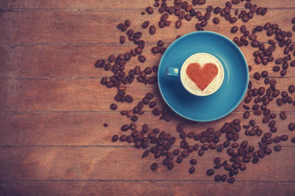 Cup of сoffee with shape heart on a wooden table. — Stock Photo, Image