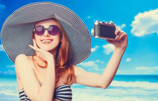 Beautiful redhead woman making selfie on a beach. — Stock Photo, Image