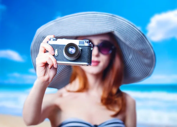 Kızıl saçlı kız sahilde retro kamera ile — Stok fotoğraf