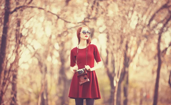 Redhead women  in a park with camera — Stock Photo, Image