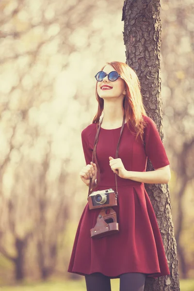 Roodharige vrouwen in een park met camera — Stockfoto