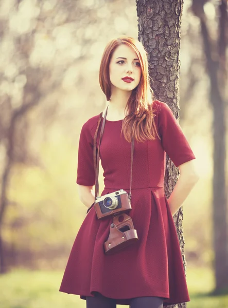 Kızıl saçlı kadın kamera ile bir parkta — Stok fotoğraf