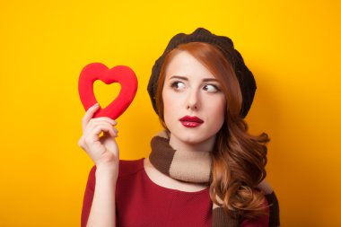 Kızıl saçlı kız sarı zemin üzerinde kalp şekli ile.