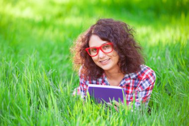 Hintli kız parkta defter ile.