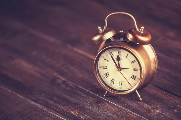 Retro alarm clock on a table. Photo in retro color image style — Stock Photo, Image