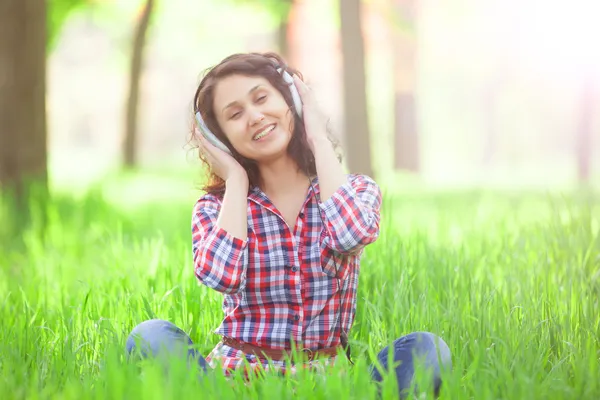 Menina indiana com fones de ouvido no parque . — Fotografia de Stock