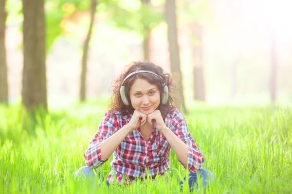 Indiase meisje met koptelefoon in het park. — Stockfoto