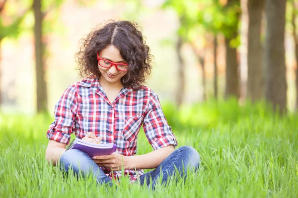 Indian girl with notebook in the park. — Stock Photo, Image
