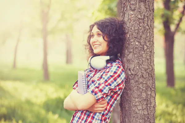 Indian girl with headphones in the park. — Stock Photo, Image