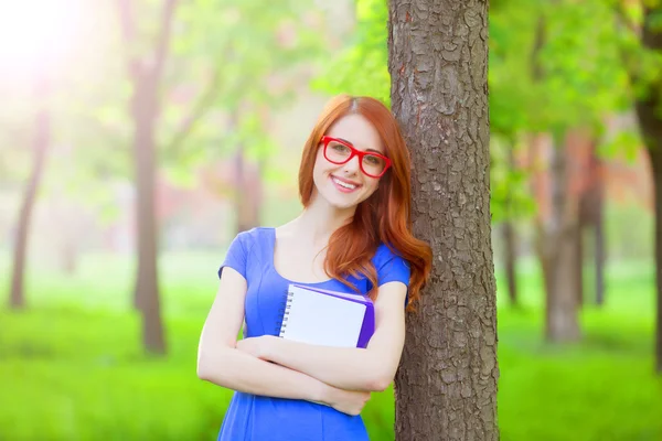 Retrato de jovem ruiva sorrindo mulher em óculos e com nota — Fotografia de Stock