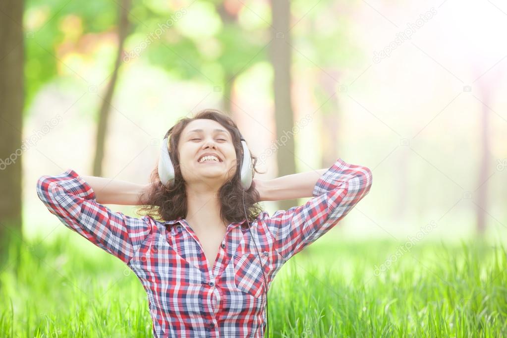 Indian girl with headphones in the park.
