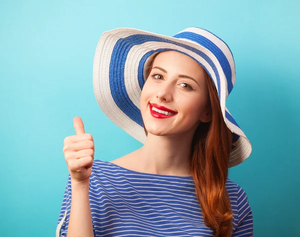 Rudowłosy dziewczyna w kapeluszu na niebieskim tle. — Zdjęcie stockowe