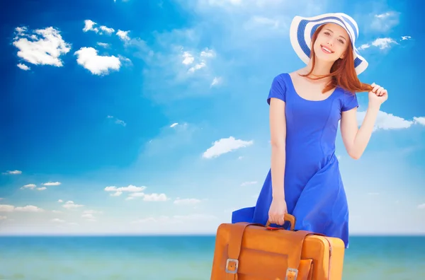 Redhead girl with suitcase on the beach in spring time. — Stock Photo, Image