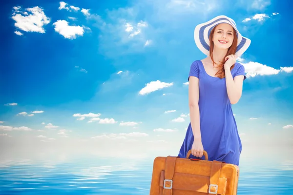 Rödhårig tjej med resväska på stranden i vår tid. — Stockfoto