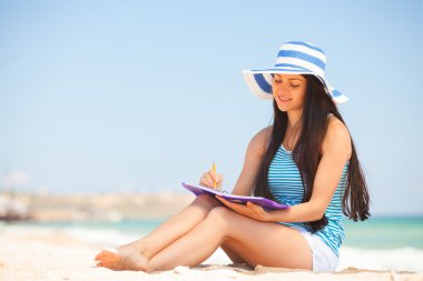 Not ve kalem ile genç esmer kız 