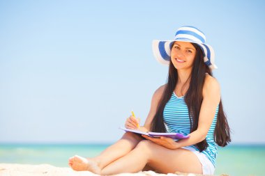 Not ve kalem ile genç esmer kız 