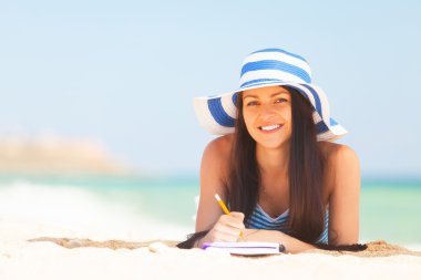 Not ve kalem ile genç esmer kız 