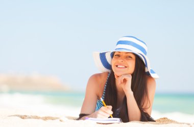 Not ve kalem ile genç esmer kız 