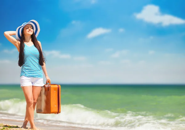 Junge brünette Mädchen mit Koffer am Strand im Sommer. — Stockfoto