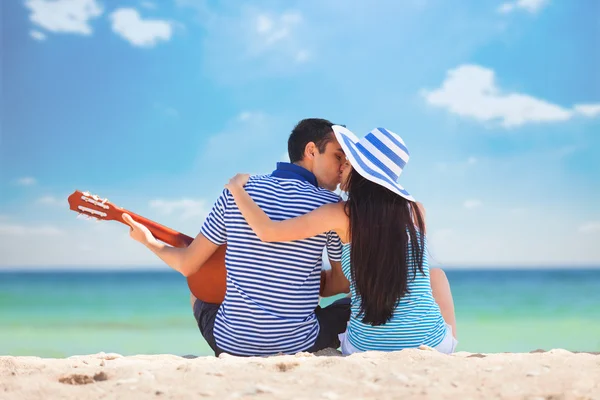 Jovem casal com guitarra na praia no dia de verão — Fotografia de Stock
