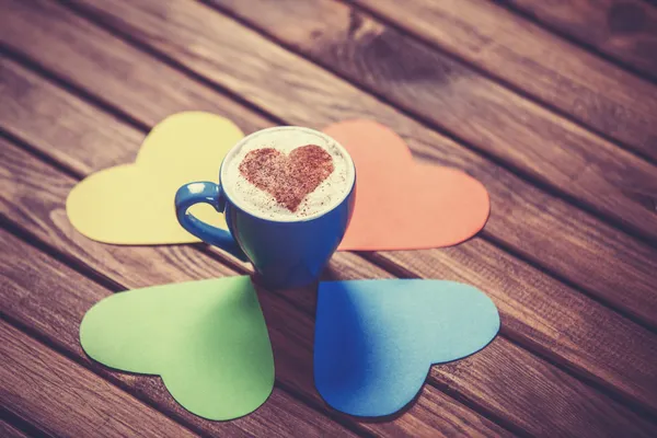 Tazza con carta da caffè e a forma di cuore su tavolo di legno . — Foto Stock