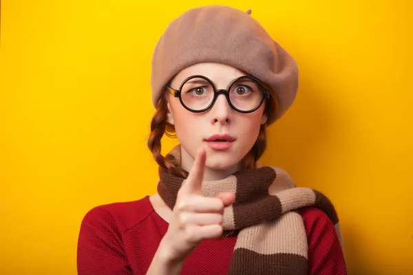 Rothaarige Mädchen mit Brille und Schal auf gelbem Hintergrund. — Stockfoto