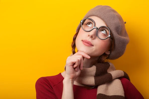 Redhead girl in glasses and scarf on yellow background. — Stock Photo, Image