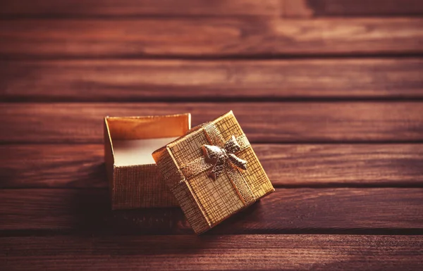 Red gift box on wooden table. — Stock Photo, Image