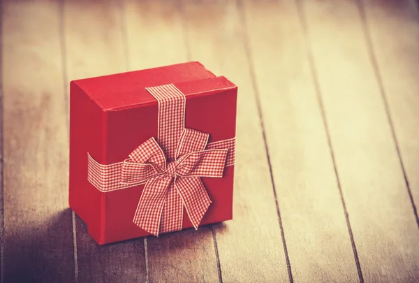 Caja de regalo roja sobre mesa de madera . — Foto de Stock