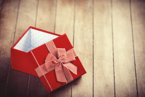 Red gift box on wooden table. — Stock Photo, Image