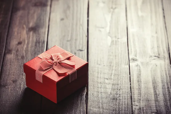 Red gift box on wooden table. — Stock Photo, Image