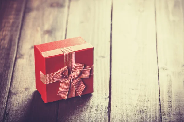 Red gift box on wooden table. — Stock Photo, Image